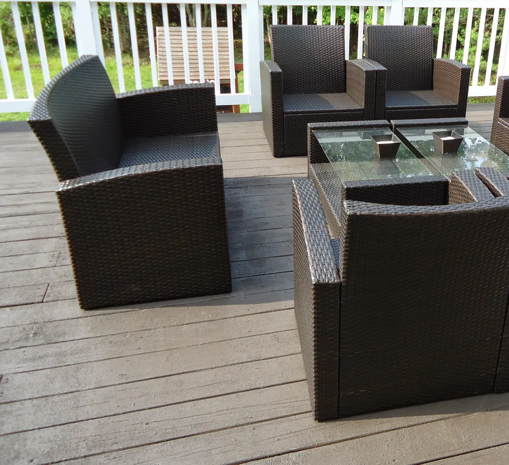 Grey composite decking with white railings and a set of outdoor lounge chairs