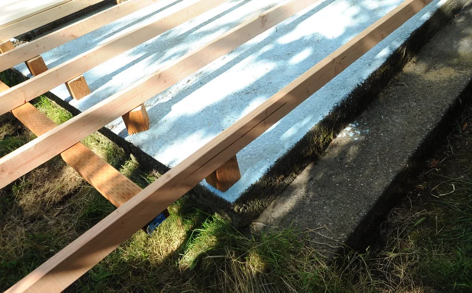 New joists and beams framed out over a levelled yard, decking not yet laid