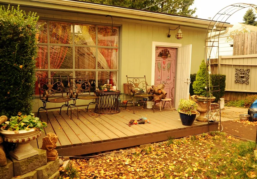Timber front deck at a single-storey house with fallen leaves across the boards