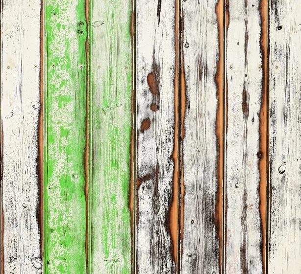 Old deck boards with green paint flaking away and gaps between them