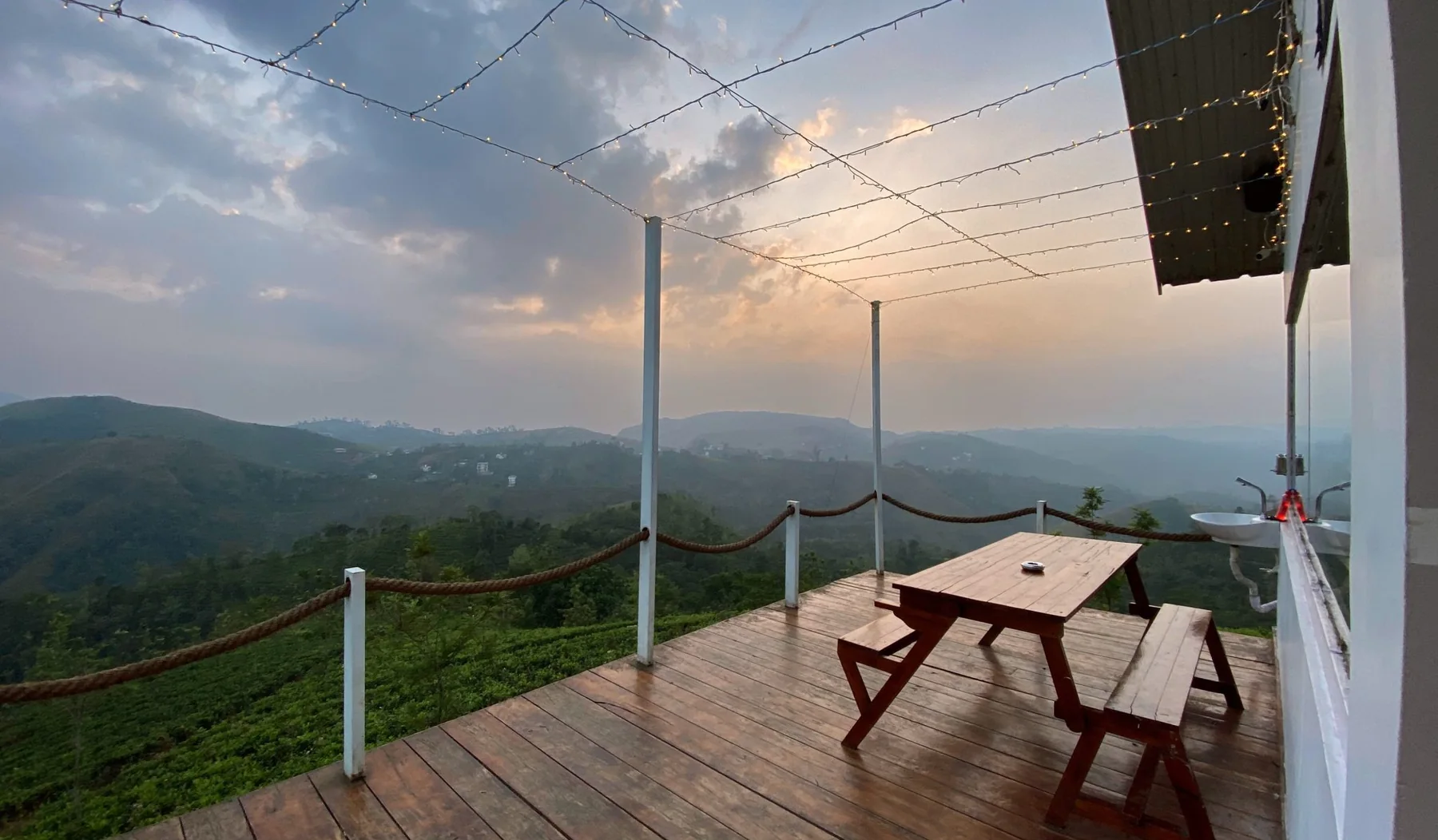 Timber deck with a picnic table and rope-edged railing looking out over a valley